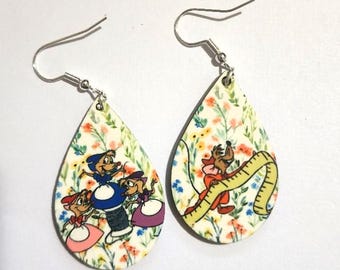 May include: A pair of teardrop-shaped earrings featuring a colourful floral background with cartoon mice characters. One earring shows three mice around a spool of thread, while the other shows a mouse holding a yellow measuring tape. Silver hooks.