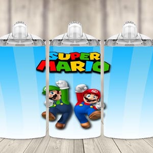 K&ouml;nnte beinhalten: Drei wei&szlig;e Trinkbecher mit Griffen, jeweils mit blauem Hintergrund und hellblauem Farbverlauf. Die Becher sind mit den Worten "SUPER MARIO" und Bildern von Mario und Luigi verziert.