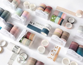 May include: Assortment of colorful washi tapes in various patterns and designs, including polka dots, stripes, and geometric shapes. The tapes are packaged in clear plastic containers with labels that say "Doing Destined Happiness" and "He Soul Makes."