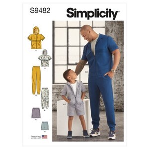 May include: Simplicity sewing pattern S9482. The image shows a man and a child wearing matching blue and gray outfits. The pattern includes options for hooded jackets, shorts, and pants. The text "Designed and printed in USA" is visible.