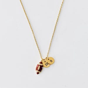 May include: Gold chain necklace with a small football charm and two round charms with the numbers 58 and 9.
