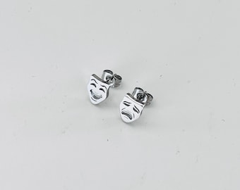 May include: A pair of silver earrings with a comedy and tragedy mask design.