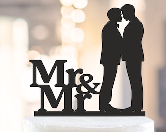 Può includere: Topper per torta in silhouette nera di due sposi in smoking che si baciano con le parole "Mr & Mr" sotto.
