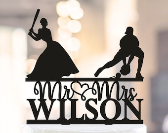 Può includere: Topper per torta in silhouette nera di una sposa e uno sposo che giocano a baseball. La sposa sta swingando una mazza e lo sposo sta giocando in campo. Il topper dice "Mr & Mrs WILSON" in un font decorativo.