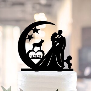 May include: Black silhouette cake topper featuring a bride and groom kissing under a crescent moon with stars. A dog and a heart with the date 11.21.23 are also included.