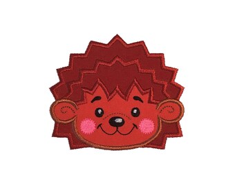May include: Embroidered patch featuring a cartoon hedgehog face. The hedgehog has a red body and spiky quills, with a lighter red face, pink cheeks, and a smiling mouth. The eyes are black, and the ears are outlined in brown.