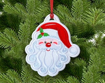 May include: A white and red embroidered Santa Claus ornament featuring a detailed face with a bushy beard, a red hat with a white trim, and a small green holly leaf with red berries on the side, suspended by a thin red ribbon loop.