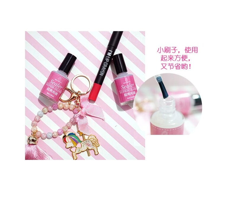 May include: Two clear bottles of nail polish with a pink and white striped background. The bottles are labeled "Sealer Super Gloss" and have a small brush applicator. A pink lip crayon is also visible in the image.