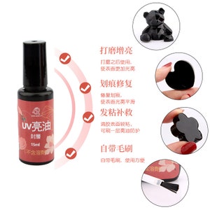 May include: A bottle of UV resin with a black cap and a white label that says "UV 亮油 封層 15ml (不含溶劑)". The bottle is surrounded by four check marks and text in Chinese characters describing the uses of the resin.