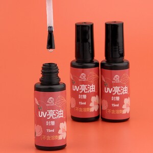 May include: Three bottles of UV clear oil, each with a black cap and a label that reads "UV 亮油 封層 15ml (不含溶劑)". The bottles are on a red background.
