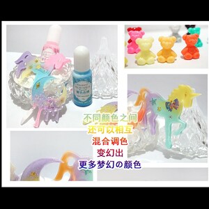 K&ouml;nnte beinhalten: Ein Set aus bunten Harz-Einhorn- und Halbmond-Anh&auml;ngern mit Glitzer- und Sternen-Akzenten. Die Anh&auml;nger werden auf einem klaren Glasst&auml;nder mit zwei Flaschen Harzfarbe pr&auml;sentiert, eine blaue und eine rosa.