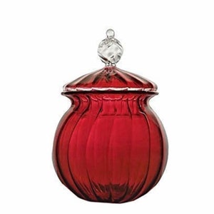Puede incluir: Un tarro de cristal rojo con tapa y un pomo decorativo transparente. El tarro tiene forma redondeada con estrías verticales, y la tapa tiene un borde festoneado. El pomo superior es transparente y en espiral.