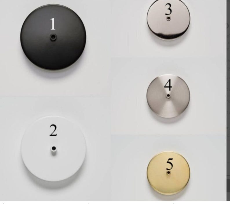 May include: A collection of five circular metal ceiling canopy plates in various finishes: black, white, brushed nickel, stainless steel, and brass. Each plate has a central hole and is labeled with a number from 1 to 5.
