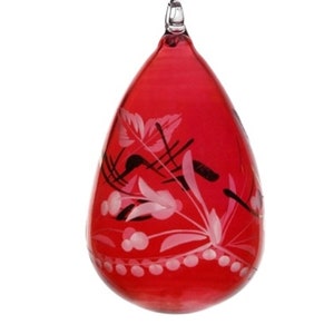 Könnte beinhalten: Ein tropfenförmiger roter Glasornament mit einer Schlaufe aus klarem Glas. Es hat ein weißes und schwarzes Blumendesign, einschließlich Blättern, Blumen und Punkten. Dieser dekorative Artikel eignet sich für festliche Dekorationen. Höhe ca. 10 cm.