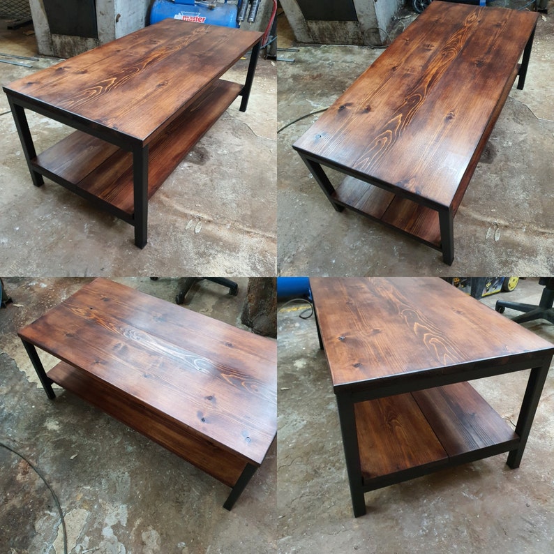 May include: A rectangular coffee table with a dark stained wood top and lower shelf. The frame is black metal. The table is approximately 48 inches long, 24 inches wide, and 18 inches high.