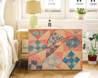 May include: A rectangular, patchwork-style painting with a light peach background and geometric patterns in blue, red, and floral prints. The artwork is displayed on a wooden surface, next to a bedside table with a lamp.