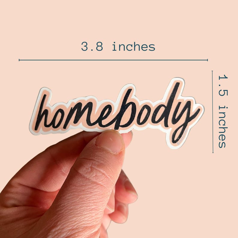 Pu&ograve; includere: Un adesivo con il testo "homebody" in corsivo nero su uno sfondo pesca. L'adesivo &egrave; largo 3,8 pollici e alto 1,5 pollici.