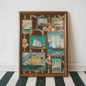 Könnte beinhalten: Ein gerahmtes Kunstwerk mit mehreren Aquarellmalereien von Segelbooten. Das Kunstwerk hat einen dunklen Hintergrund mit floralen und kettenartigen Mustern. Der Rahmen ist warmbraun, und die Gemälde zeigen Segelboote auf dem Wasser.