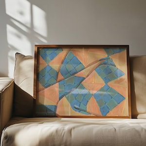 Pode incluir: Pintura abstrata emoldurada em madeira. A obra apresenta um design geométrico com formas azuis, laranja e amarelas. A pintura é exibida em um sofá bege, com a luz do sol projetando sombras na parede.