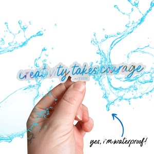 K&ouml;nnte beinhalten: Ein wei&szlig;er Aufkleber mit dem Text "creativity takes courage -MATISSE" in bunter Schrift. Der Aufkleber wird von einer Hand gehalten und ist von blauen Wasserspritzern umgeben. Der Text "yes, i'm waterproof!" steht unter dem Aufkleber.