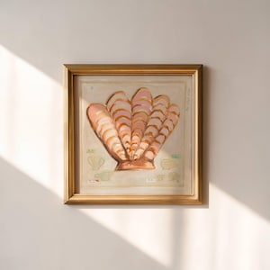 May include: A framed artwork featuring a large, stylized seashell in shades of pink and peach. The shell is the focal point, set against a neutral background. The frame is gold-toned, adding a touch of elegance.