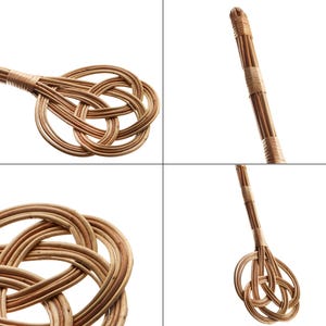 May include: A brown wicker broom with a knotted handle. The broom is made of natural materials and has a rustic look.