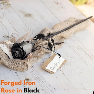 May include: A black forged iron rose with a tag that says "Rose for you". The rose is resting on a burlap cloth. The text "Forged Iron Rose in Black" is at the bottom of the image.
