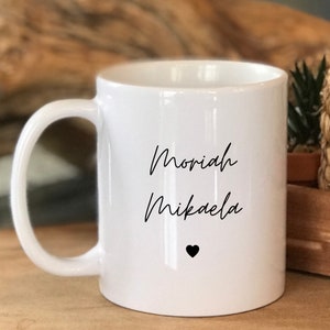 May include: White ceramic mug with black text that reads "Moriah Mikaela" and a small black heart.
