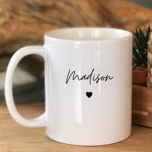 May include: White ceramic mug with a black handwritten name "Madison" and a small black heart.