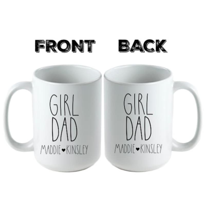 May include: Two white ceramic mugs with black text that reads "Girl Dad" and the names "Maddie" and "Kinsley" on the front and back.