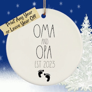 May include: White ceramic ornament with black text that reads "OMA and OPA EST 2023" with two black footprints below the text.