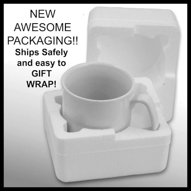 May include: A white ceramic mug with a handle is nestled in a white styrofoam packaging. The packaging is designed to protect the mug during shipping and makes it easy to gift wrap.