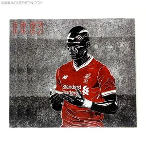 May include: A black and white illustration of a soccer player wearing a red jersey with the text "Standard Chartered" and the Liverpool Football Club logo. The player is looking down and holding his hands together.
