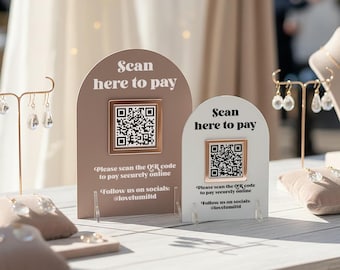 May include: Two arched payment signs with QR codes. The larger sign is dusty rose with white text, and the smaller is white with black text. Both read: Scan here to pay, Please scan the QR code to pay securely online, Follow us on socials: @lovelumiltd.