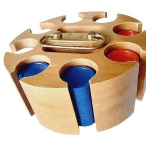 May include: A wooden poker chip holder with a brass handle. The holder is circular with slots for chips, some filled with blue and red chips. The wood has a light, natural finish.