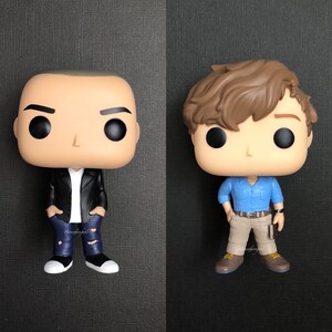 May include: Two vinyl figures, one with brown hair and a blue shirt, the other with a black leather jacket and blue jeans.