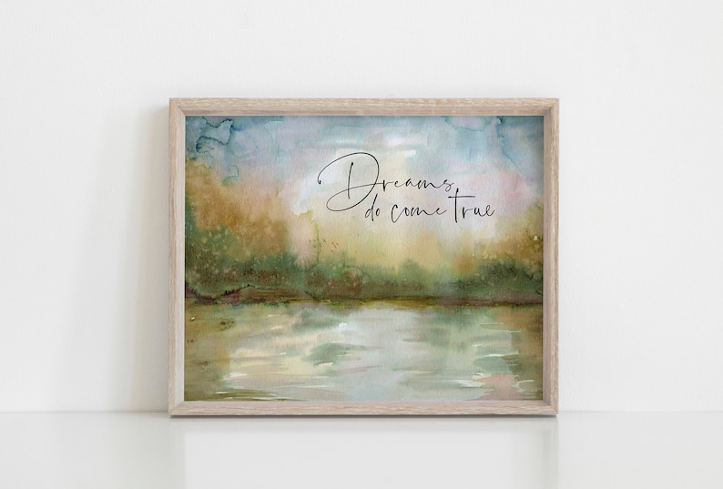 May include: A framed watercolor painting of a lake with trees in the background. The text "Dreams do come true" is written in black cursive script on the painting.