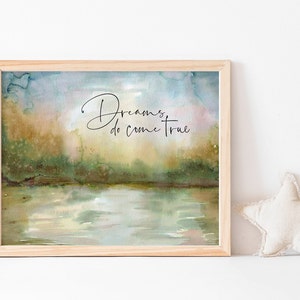 May include: A framed watercolor painting of a lake scene with a quote that reads "Dreams do come true". The painting has a soft, dreamy feel with shades of blue, green, and brown.