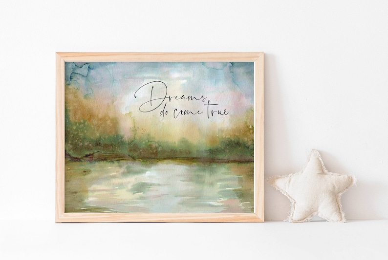 May include: A framed watercolor painting of a lake scene with a quote that reads "Dreams do come true". The painting has a soft, dreamy feel with shades of blue, green, and brown.