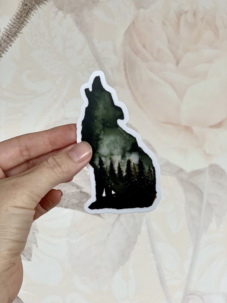 May include: A black and green watercolour sticker of a wolf howling at the moon. The wolf is silhouetted against a forest scene.
