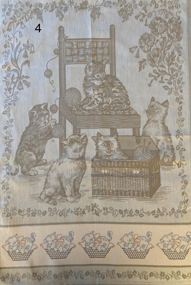 Peut inclure: Une tapisserie beige repr&eacute;sentant une sc&egrave;ne de quatre chatons jouant avec des pelotes de laine. Les chatons sont dans diff&eacute;rentes positions, l'un assis sur une chaise, l'autre dans un panier et les deux autres sur le sol. La tapisserie a une bordure florale et une bordure inf&eacute;rieure de paniers tiss&eacute;s.