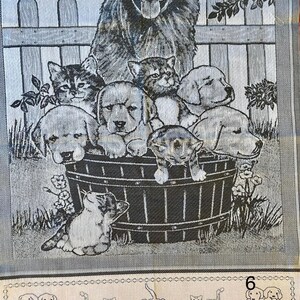Peut inclure: Une tapisserie en noir et blanc repr&eacute;sentant un grand chien avec un groupe de chiens et de chats plus petits dans un tonneau. La tapisserie a un fond gris avec une cl&ocirc;ture blanche et une v&eacute;g&eacute;tation verte.
