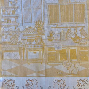 Peut inclure: Une serviette de cuisine jaune sur fond blanc repr&eacute;sentant une sc&egrave;ne de cuisine avec une cuisini&egrave;re, des armoires et une fen&ecirc;tre. La serviette est bord&eacute;e de chats et de souris. Le chiffre "2" se trouve dans le coin sup&eacute;rieur gauche de la serviette. Le texte "Prodotto in Italia" se trouve dans le coin inf&eacute;rieur gauche de la serviette.