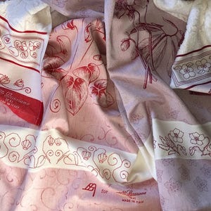 Può includere: Un tessuto bianco e rosa con un motivo floreale rosso e il testo "F.lli Giannisama Real Made in Italy".