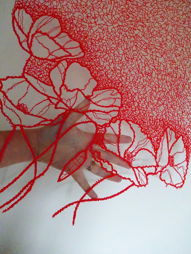 Puede incluir: Dise&ntilde;o floral rojo impreso en 3D con una mano sosteniendo la parte inferior del dise&ntilde;o. El dise&ntilde;o est&aacute; hecho de l&iacute;neas finas e intrincadas que crean un efecto delicado y aireado.