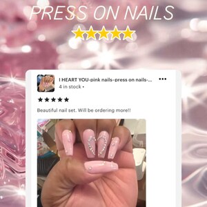 May include: Pink press-on nails with a heart design and rhinestones. The nails are long and coffin shaped. The caption reads "I HEART YOU-pink nails-press on nails... 4 in stock." and "Beautiful nail set. Will be ordering more!!"