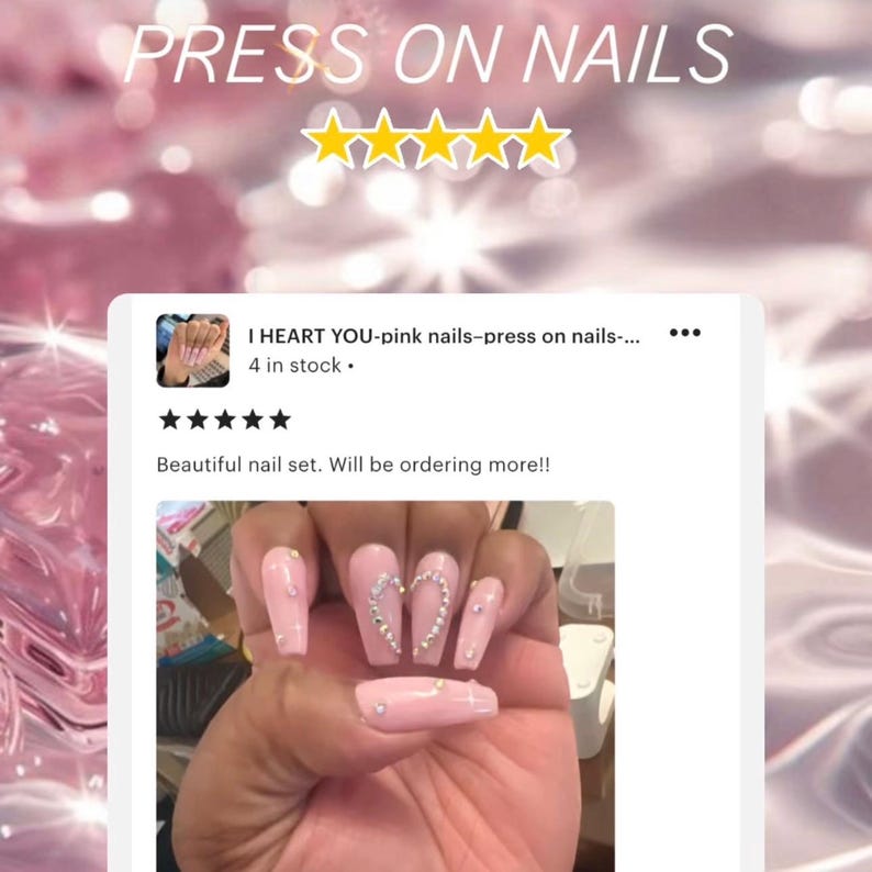 May include: Pink press-on nails with a heart design and rhinestones. The nails are long and coffin shaped. The caption reads "I HEART YOU-pink nails-press on nails... 4 in stock." and "Beautiful nail set. Will be ordering more!!"
