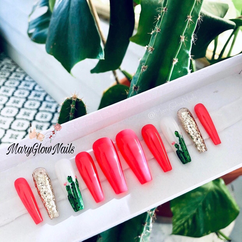 May include: Set of ten pink long false nails with a cactus design. The nails are in a white box with the text "MaryGlowNails" on the front.