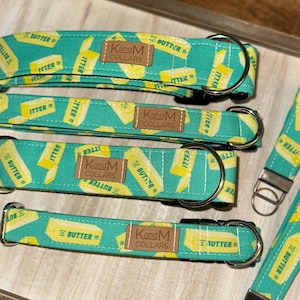 May include: Four green and yellow dog collars with a butter print and the text "KandM Collars" and a matching green and yellow dog leash with a butter print and the text "BUTTER".
