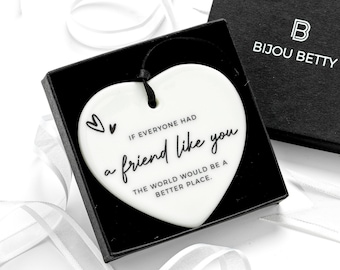May include: A white heart-shaped ceramic ornament with a black string, featuring the printed text "IF EVERYONE HAD a friend like you THE WORLD WOULD BE A BETTER PLACE." and two small heart outlines, presented in a black gift box labelled "BIJOU BETTY".